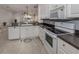 Well-lit kitchen boasting white cabinets, granite countertops, and a breakfast bar at 1931 San Silvestro Dr, Venice, FL 34285