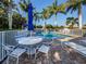 Relaxing poolside patio furniture with umbrellas at 1931 San Silvestro Dr, Venice, FL 34285