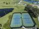 Aerial view of two well-maintained tennis courts at 1931 San Silvestro Dr, Venice, FL 34285
