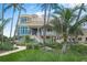Luxury home with palm trees, manicured lawn, and walkway at 213 The Esplanade S, Venice, FL 34285