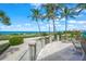 Ocean view patio with seating area, glass railing, and lush landscaping at 213 The Esplanade S, Venice, FL 34285