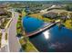 Aerial view of a luxury community with lake and walking bridge at 224 Ariano Ave, Nokomis, FL 34275