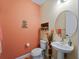 Small bathroom with toilet and sink, coral decor at 224 Ariano Ave, Nokomis, FL 34275