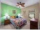 Bedroom with a queen bed, ceiling fan, and tropical decor at 224 Ariano Ave, Nokomis, FL 34275