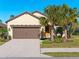 Single-story home with brown garage door, landscaping, and palm trees at 224 Ariano Ave, Nokomis, FL 34275