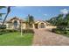 House exterior featuring a paver driveway and manicured lawn at 256 Royal Oak Way, Venice, FL 34292