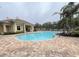Inviting community pool with a surrounding brick patio and clubhouse at 2890 Whispering Pine Ln, North Port, FL 34287