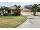 Single-story home with attached garage and manicured lawn at 2890 Whispering Pine Ln, North Port, FL 34287