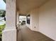 Side view of covered front porch with tiled flooring at 2890 Whispering Pine Ln, North Port, FL 34287