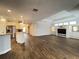 Open living room with hardwood floors, kitchen island, and built-in entertainment center at 2890 Whispering Pine Ln, North Port, FL 34287