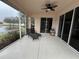 Relaxing screened porch overlooking a lake, with lounge chairs and ceiling fan at 2890 Whispering Pine Ln, North Port, FL 34287