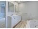 Bathroom with double vanity, marble accents, and soaking tub at 3187 Galiot Rd, Venice, FL 34293