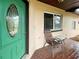 Inviting front porch with green door and seating area at 3187 Galiot Rd, Venice, FL 34293