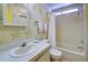 Second bathroom with tub, single sink vanity, and leaf wallpaper at 3300 Blue Jay Ln, Englewood, FL 34224