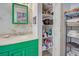 Bathroom with green vanity, storage, and bamboo wallpaper at 3300 Blue Jay Ln, Englewood, FL 34224