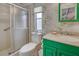 Bathroom features a green vanity, shower stall and bamboo wallpaper at 3300 Blue Jay Ln, Englewood, FL 34224