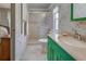 Clean bathroom with green vanity, shower/tub combo, and bamboo wallpaper at 3300 Blue Jay Ln, Englewood, FL 34224