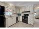 Efficient kitchen features white cabinets, black appliances, and a tile floor at 3300 Blue Jay Ln, Englewood, FL 34224