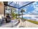 Screened patio with lake view, featuring a grill and comfortable seating at 400 Maraviya Blvd, Nokomis, FL 34275