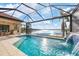 Resort-style pool with covered lanai, water feature, and lake view at 400 Maraviya Blvd, Nokomis, FL 34275