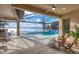 Covered patio overlooking a pool and lake with wicker furniture at 400 Maraviya Blvd, Nokomis, FL 34275