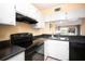Bright kitchen features black appliances and white cabinets at 408 Cerromar S Cir # 132, Venice, FL 34293