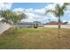 Backyard with gray house, lush trees and patio at 4310 Albacore Cir, Port Charlotte, FL 33948