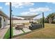 Outdoor patio area with shade sail, furniture and green space at 4310 Albacore Cir, Port Charlotte, FL 33948