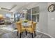 Charming dining area with glass table and four yellow chairs at 438 Grand Preserve Cv, Bradenton, FL 34212
