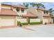 Tan two-story condo building with tile roofs, attached garages, and lush landscaping at 440 Palmetto Ct # 3, Venice, FL 34285