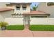 Front view of a charming condo with a terracotta roof and gated entryway at 440 Palmetto Ct # 3, Venice, FL 34285