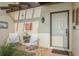 Inviting entryway with white chairs, brick floor, and a hanging wind chime at 440 Palmetto Ct # 3, Venice, FL 34285