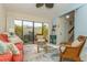 Spacious living area with coral sofa and wicker armchairs, and view of patio at 440 Palmetto Ct # 3, Venice, FL 34285