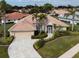 Single-story home with tile roof, landscaping, and driveway at 5045 Whitestone Dr, Venice, FL 34293