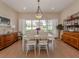 Spacious dining room with hardwood floors and large window overlooking garden at 5045 Whitestone Dr, Venice, FL 34293