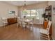 Bright dining room with hardwood floors, white table, and large window at 5045 Whitestone Dr, Venice, FL 34293