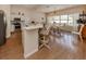 Open concept kitchen with island, dining area, and hardwood floors at 5045 Whitestone Dr, Venice, FL 34293