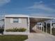 Tan mobile home with carport and landscaping at 516 Ashwood Dr, Venice, FL 34285