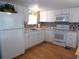 White kitchen with granite countertops, mosaic backsplash, and stainless steel appliances at 516 Ashwood Dr, Venice, FL 34285