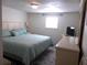 King size bed, light teal bedding, and dresser with TV at 516 Ashwood Dr, Venice, FL 34285