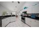 Modern kitchen with white cabinets, granite countertops, and stainless steel appliances at 538 Laurel Cherry Ln, Venice, FL 34293