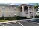 Exterior shot of a condo building featuring ample parking and manicured landscaping in front at 5800 Sabal Trace Dr # 701, North Port, FL 34287