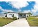 Single-wide manufactured home with carport and landscaped yard at 6139 Shearwater Dr, Englewood, FL 34224