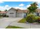 Tan two-car garage villa with landscaped yard at 640 Back Nine Dr, Venice, FL 34285