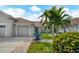 Tan two-car garage villa with landscaped yard at 640 Back Nine Dr, Venice, FL 34285