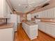 Spacious kitchen with island, white cabinets, and hardwood floors at 651 Lakescene Dr, Venice, FL 34293