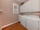 Bright laundry room with washer, dryer, cabinets, and wood floors at 651 Lakescene Dr, Venice, FL 34293