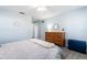 Serene bedroom with light blue walls, wood dresser, and neutral bedding at 664 Linden Dr, Englewood, FL 34223