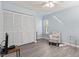 Spacious bedroom with light walls, a comfortable armchair, and large closet at 664 Linden Dr, Englewood, FL 34223