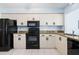 Modern kitchen featuring granite countertops, black appliances, and ample cabinetry at 664 Linden Dr, Englewood, FL 34223